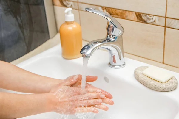 Ein Händewaschen mit Seife unter dem Wasserhahn mit Wasser — Stockfoto