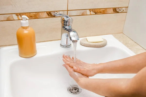 Ein Händewaschen mit Seife unter dem Wasserhahn mit Wasser — Stockfoto