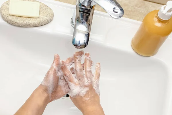 A Lavarsi le mani con il sapone sotto il rubinetto con acqua — Foto Stock