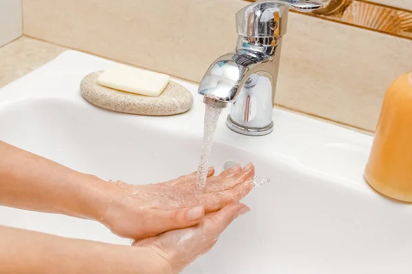 A Lavarsi le mani con il sapone sotto il rubinetto con acqua — Foto Stock