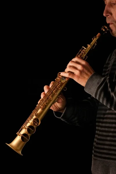 Сопрано саксофон в руках хлопця на чорному тлі — стокове фото