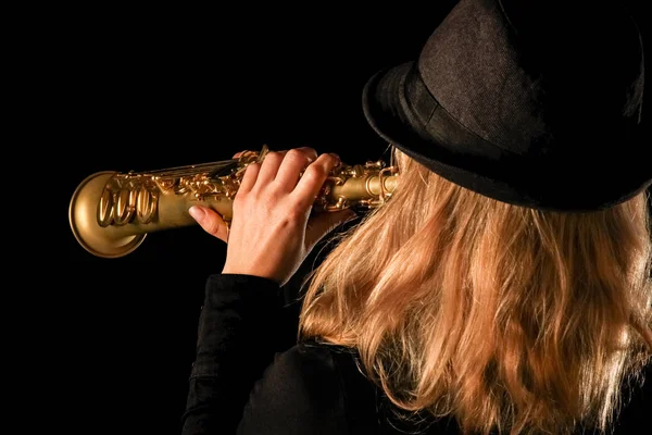 Soprano saxophone in the hands of a girl on a black background — Stock Photo, Image