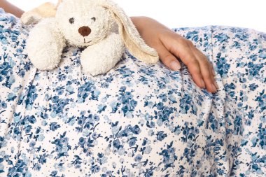 Mutlu hamile kız beyaz arka planda yatıyor.