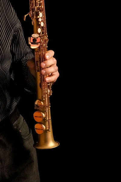 Soprano saxophone in the hands of a guy on a black background — Stock Photo, Image