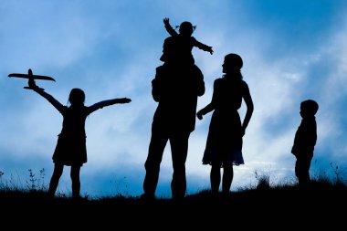 Deniz kenarında mutlu bir aile, doğanın siluetinde.