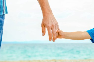 doğada deniz tarafından mutlu bir ebeveyn ve çocuğun güzel elleri