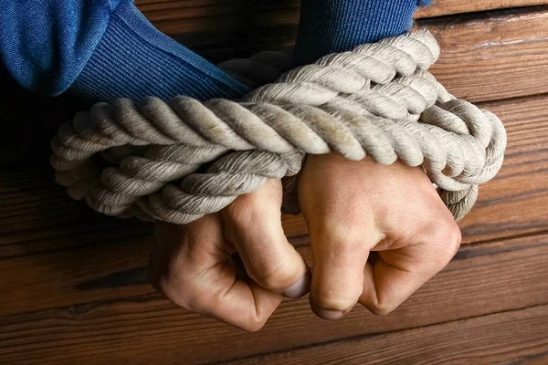 Ahşap bir arka planda ipi olan eller.