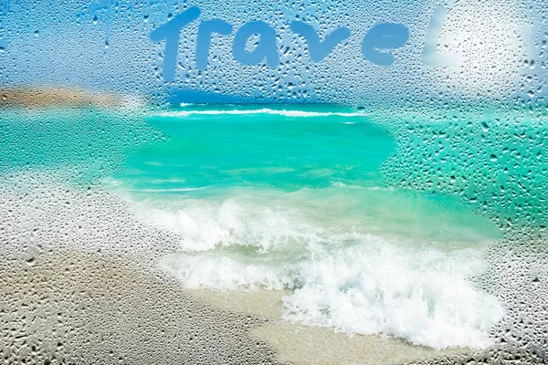 beautiful beach with waves through the window with drops on a background of nature