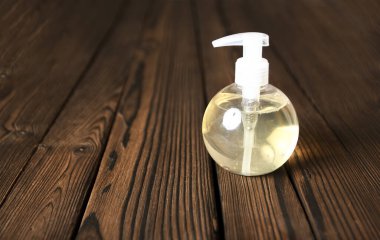 Ahşap arka planda bir kavanoz sıvı sabun