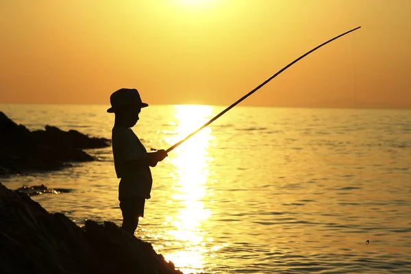 Silhueta Menino Com Uma Vara Pesca Pôr Sol — Fotografia de Stock