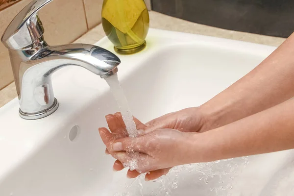 水で蛇口の下に石鹸で手を洗う — ストック写真