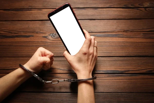 phone with hands addiction on a wooden background