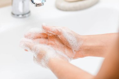  Musluğun altında sabunla ellerini yıkamak, suyla.