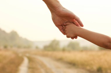 Ebeveyn küçük bir çocuğun elini tutar.