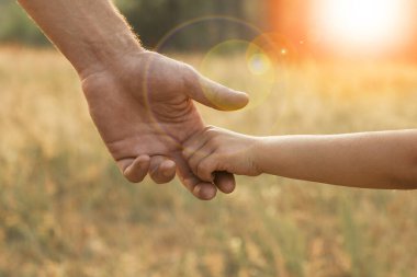 Ebeveyn küçük bir çocuğun elini tutar.