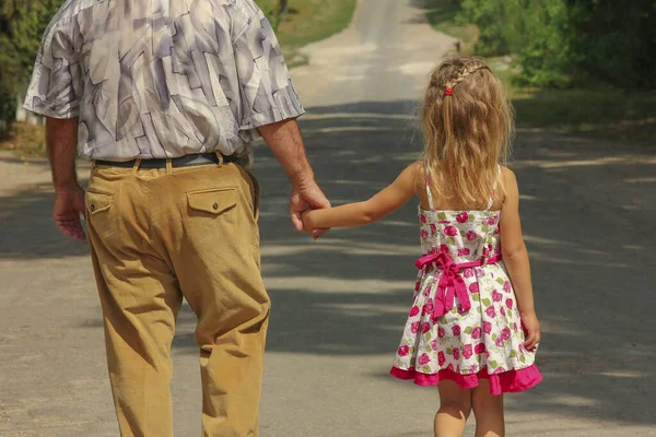 爷爷带着幸福的孙子走在路上 — 图库照片