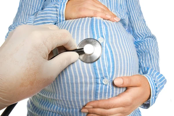 一个白种人背景的快乐的怀孕女孩在一位医生的旁边 她带着听诊器 听着女人的胃 — 图库照片