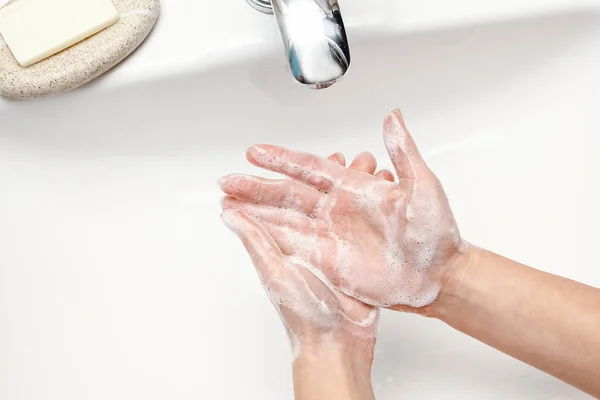 Hands with soap are washed under the tap with water. Clean from infection and dirt and virus. At home or in the hospital ablution office.