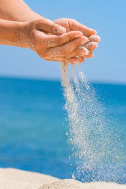 Eller bir yolculukta denizden doğaya kum döker. Deniz kumu üzerinde tatiller geçer. İş zamanı.