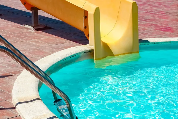 Steps with slide in the pool by the sea nature background. For bathing turquoise water.