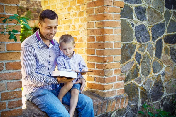 一个年轻的父亲和一个快乐的儿子读 关于自然的内容 — 图库照片