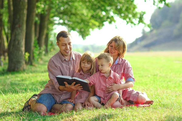 自然の中で聖書を読む幸せな若い家族 — ストック写真