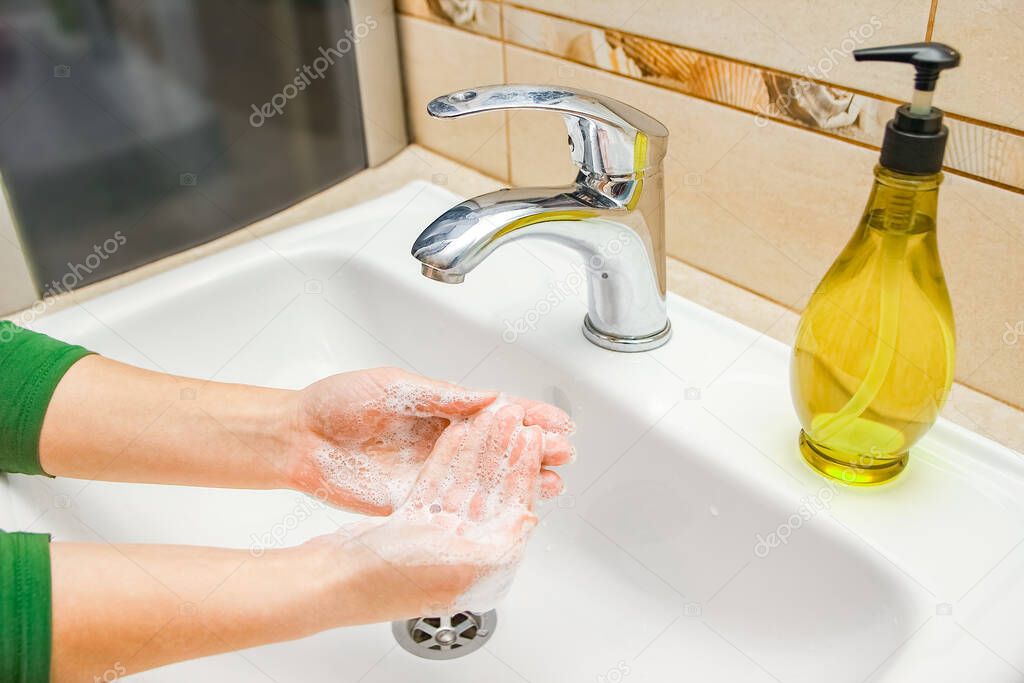 Hands with soap are washed under the tap with water. Clean from infection and dirt and virus. At home or in the hospital ablution office.