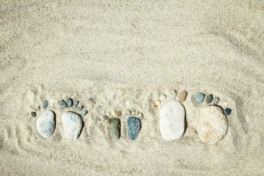 Mutlu bir ayak. Taş, okyanus kıyısındaki sahildeki ayak izleri gibi. Deniz arkaplanı.