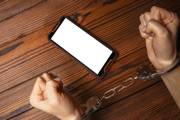 木製の背景に手中毒の携帯電話 — ストック写真