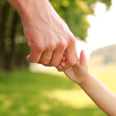 Ebeveyn küçük bir çocuğun elini tutar.