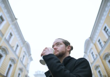 Sakallı adam kahve içme ve binaya arıyorsunuz.