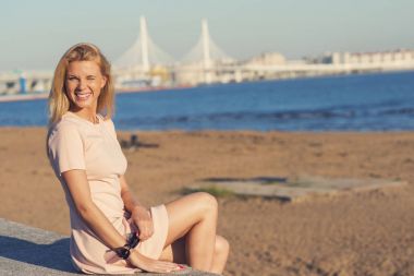 Sahilde - gözleri daralma ve gülümseyen güzel sarışın kız