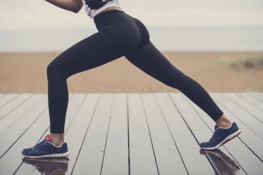 Bir ince sportif kız açık havada egzersiz bir kumsalda alt beden