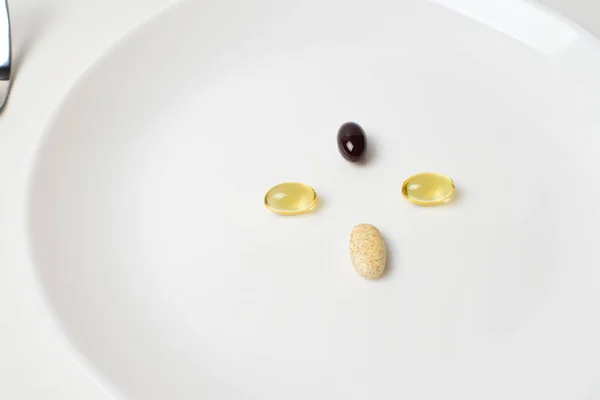 Compléments alimentaires multivitaminés et minéraux. Astaxanthine. Assiette avec comprimés. Remplacement de repas. Gros plan . — Photo