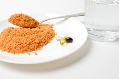 Kaşık üzerinde domates proteini çorbası. El barutu su bardağına koyar. Yemek değişimi. Kuru çorba. Multivitaminler, uyuşturucu, balık yağı, omega hapları. Yakın çekim..