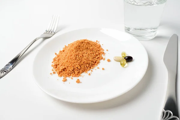 Sopa de proteína de tomate en polvo en una cuchara. Mano pone el polvo en el vaso de agua. Reemplazo de comida. Sopa seca. Multivitaminas, astaxantina, aceite de pescado, píldoras omega. Primer plano. . — Foto de Stock
