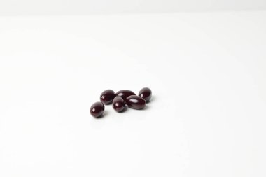 Group of astaxanthin capsules scattered on a white background.