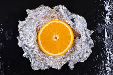 İndirimli sulu portakal, granit bir tabakta suyla karartılmış.