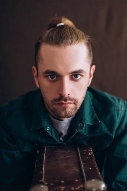 Karanlık bir arka planda erkek portresi. Saçları tomar tomar dökülen adam. Fotoğraf seyahat ve rahatlama arzusunu yansıtıyor..