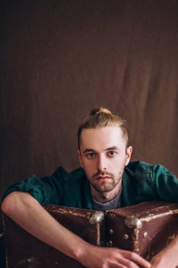 Karanlık bir arka planda erkek portresi. Saçları tomar tomar dökülen adam. Fotoğraf seyahat ve rahatlama arzusunu yansıtıyor..