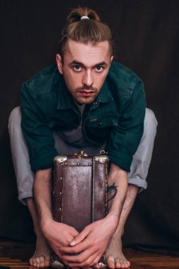 Karanlık bir arka planda erkek portresi. Saçları tomar tomar dökülen adam. Fotoğraf seyahat ve rahatlama arzusunu yansıtıyor..