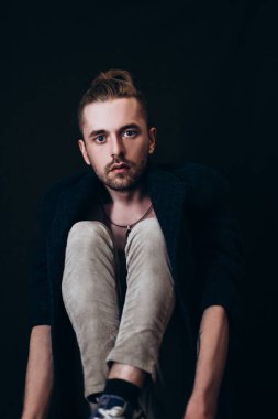 Karanlık bir arka planda erkek portresi. Saçları tomar tomar dökülen adam. Fotoğraf seyahat ve rahatlama arzusunu yansıtıyor..