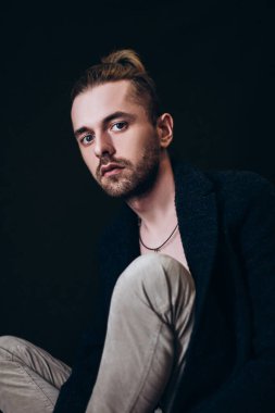 Karanlık bir arka planda erkek portresi. Saçları tomar tomar dökülen adam. Fotoğraf seyahat ve rahatlama arzusunu yansıtıyor..