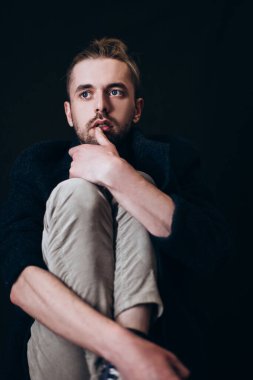 Karanlık bir arka planda erkek portresi. Saçları tomar tomar dökülen adam. Fotoğraf seyahat ve rahatlama arzusunu yansıtıyor..