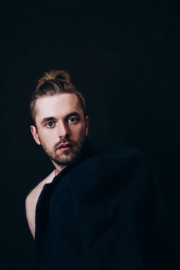 Karanlık bir arka planda erkek portresi. Saçları tomar tomar dökülen adam. Fotoğraf seyahat ve rahatlama arzusunu yansıtıyor..