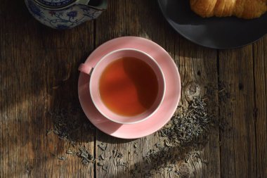 Ahşap arka planda güzel kokulu çay kokulu pembe kupa. Çay havası. Çay bileşimi.