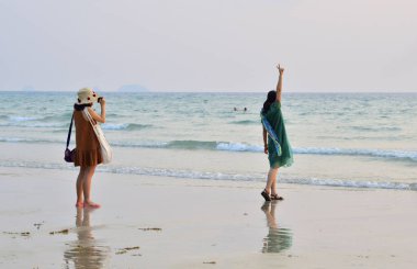 İki genç turist sahildeki bir akıllı telefondan fotoğraf çekiyor. Ko Chang, Tayland-8 Şubat 2018
