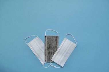 Mavi arka planda tıbbi koruyucu maskeler. Bir insanı virüslerden, bakterilerden ve tozdan korumak için tek kullanımlık maskeler. Koronavirüse karşı ilk koruma.
