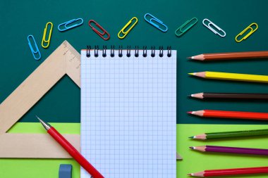 Renkli bir arka planda okul kırtasiyesinin düz kompozisyonu. Yukarıdan görünüşü.