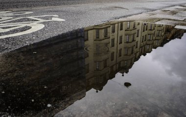 Sokağın ortasında bir su havuzu evlerde yansımaları